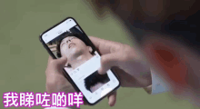 a person is holding a cell phone with a picture of a man 's face on it .