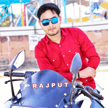 a man wearing sunglasses is sitting on a motorcycle that says rajput on the front