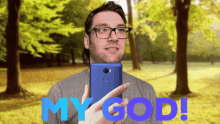 a man with glasses is holding a cell phone with the words my god in blue letters