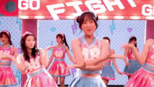 a group of girls are dancing in front of a sign that says go fight go