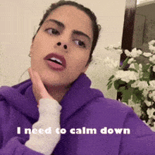 a woman is wearing a purple hoodie and says i need to calm down