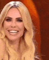 a close up of a woman 's face with blonde hair smiling