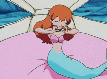 a cartoon of a mermaid laying on a bed with her eyes closed