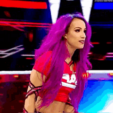 a woman with purple hair is wearing a red shirt that says eaa