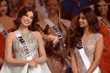 a group of women are standing next to each other with one wearing a sash that says paraguay .