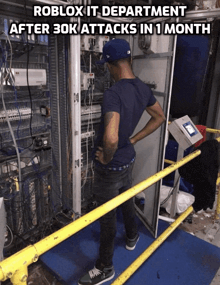 a man standing in front of a box with the words roblox it department after 30k attacks in 1 month written above him