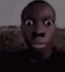 a man with a mustache is making a funny face with his eyes wide open .