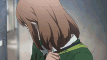 a girl with brown hair is wearing a green shirt