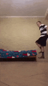 a man is jumping over a bed with a santa claus blanket