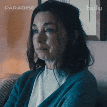a woman is sitting on a couch with a hulu logo in the background