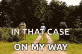 a man is walking down a dirt road in a field .