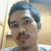 a man with a beard is taking a selfie with his mouth open