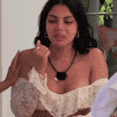a woman wearing a white lace top has a tattoo on her arm