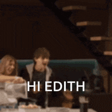 a blurry picture of people sitting at a table with the words hi edith written in white