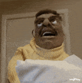 a man in a yellow sweater is holding a piece of paper with a surprised look on his face ..