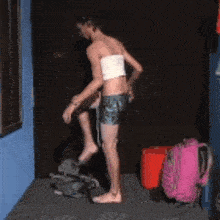 a man is standing in a room with a pink backpack