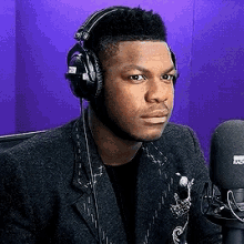 a man wearing headphones sits in front of a microphone that says bbc radio