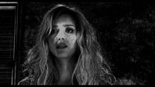 a black and white photo of a woman with long wavy hair