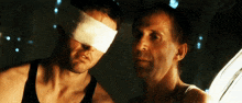 a man with a bandage on his eye is looking at another man