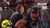 a woman is being held by a man in front of a raw sign