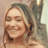 a close up of a woman 's face with her eyes closed smiling