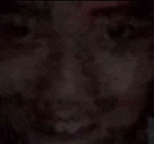 a close up of a man 's face in a dark room .