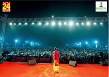 a man stands on a stage in front of a crowd with a news 24 logo on the bottom