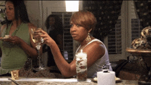 a woman holds a glass of wine while another woman holds a plate of food
