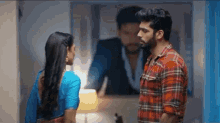 a man and a woman are standing next to each other and looking at each other in a room .