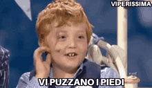 a young boy is holding his ear and says vi puzzano i piedi .