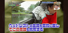 a man in a red shirt is sitting in the driver 's seat of a car with foreign writing on the screen
