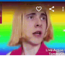 a man with blonde hair is making a funny face while wearing a red shirt .