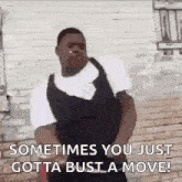 a man is standing in front of a brick wall and smoking a cigarette while dancing .