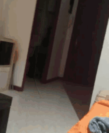 a person is walking through a doorway in a room with a bed .