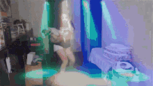 a woman is dancing in a room with a purple light behind her