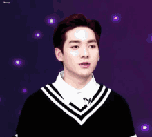 a young man wearing a black and white sweater and a white shirt with cherry written on the bottom