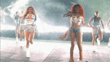 a group of women are dancing on a stage and one of them has a shirt that says ' dirty ' on it