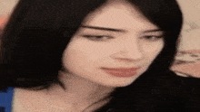 a close up of a woman 's face with long black hair .