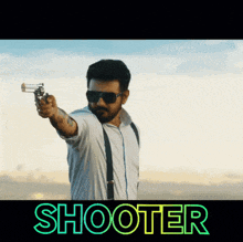 a man is pointing a gun with the word shooter behind him