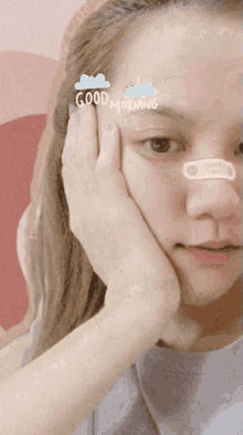 a woman with a bandage on her nose and the words good morning on her forehead