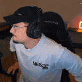 a man wearing headphones and a white shirt that says meiset