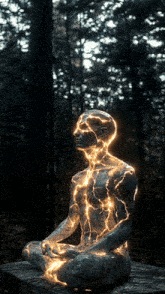 a statue of a man in a lotus position with light coming out of his chest