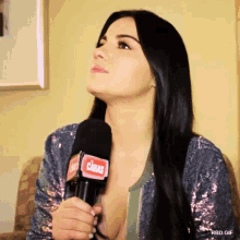 a woman is holding a microphone that says caras