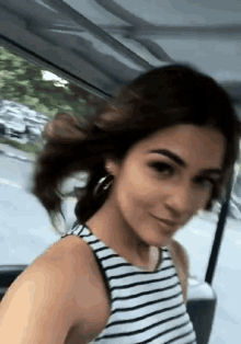 a woman in a striped tank top is smiling