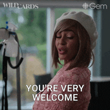 a woman wearing a pink sweater and a white beret says you 're very welcome