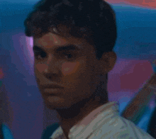 a young man with curly hair is holding a glass of water