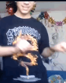 a man wearing a black shirt that says ' apocalypse ' on it is dancing