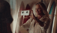 a woman is taking a picture of herself with a white box
