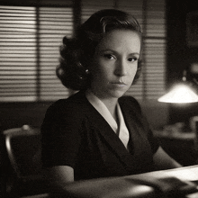 a black and white photo of a woman in a suit