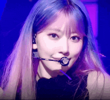a woman with blue hair is wearing a microphone around her neck